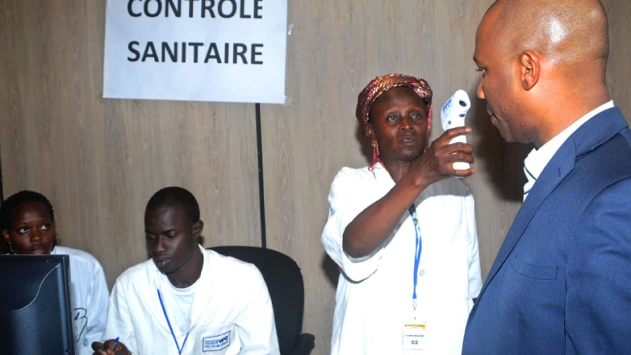 Airport employees check passengers before they leave the country