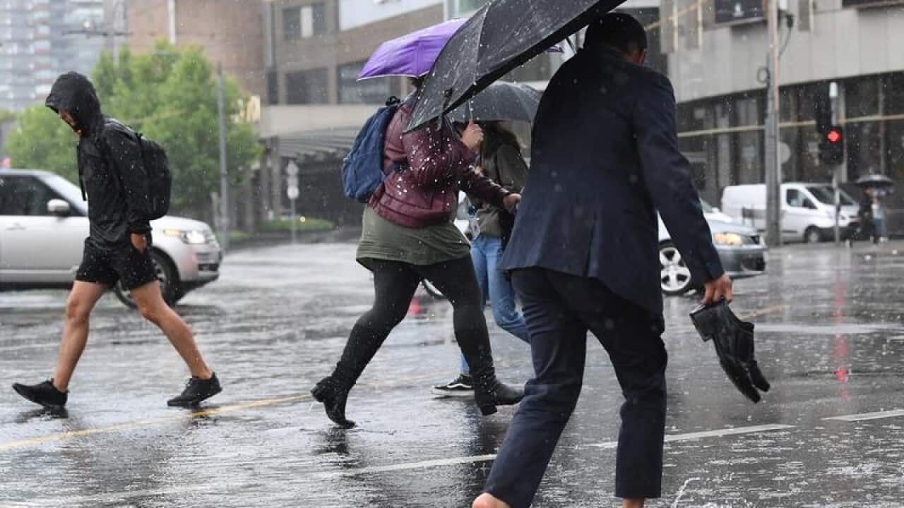 Pedestrians walk through flood waters.
