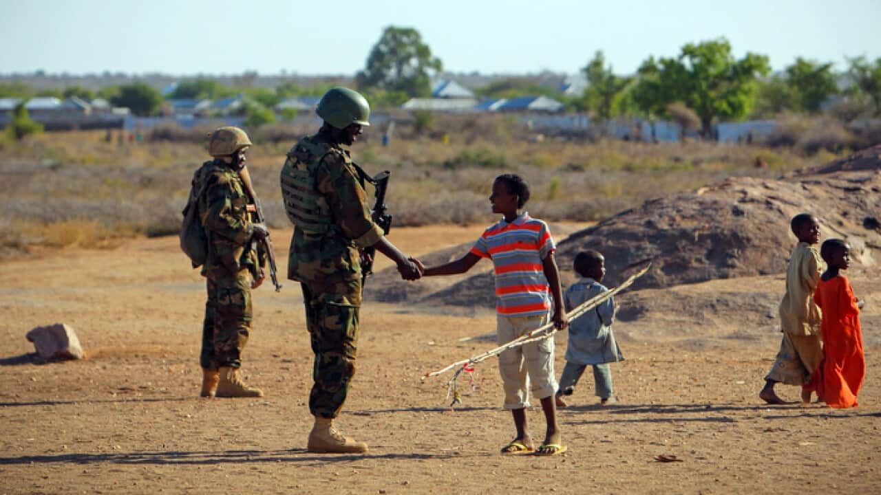 A Somali boy greeting a Ugandan soldier serving with the African Union Mission in Somalia (AMISOM) in the central town of Buur-Hakba