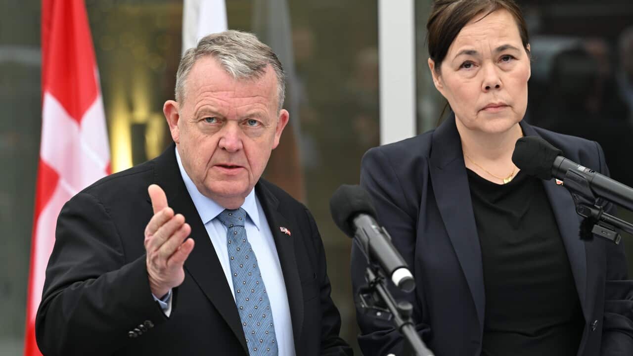 A man and a woman wearing suits holding a press conference