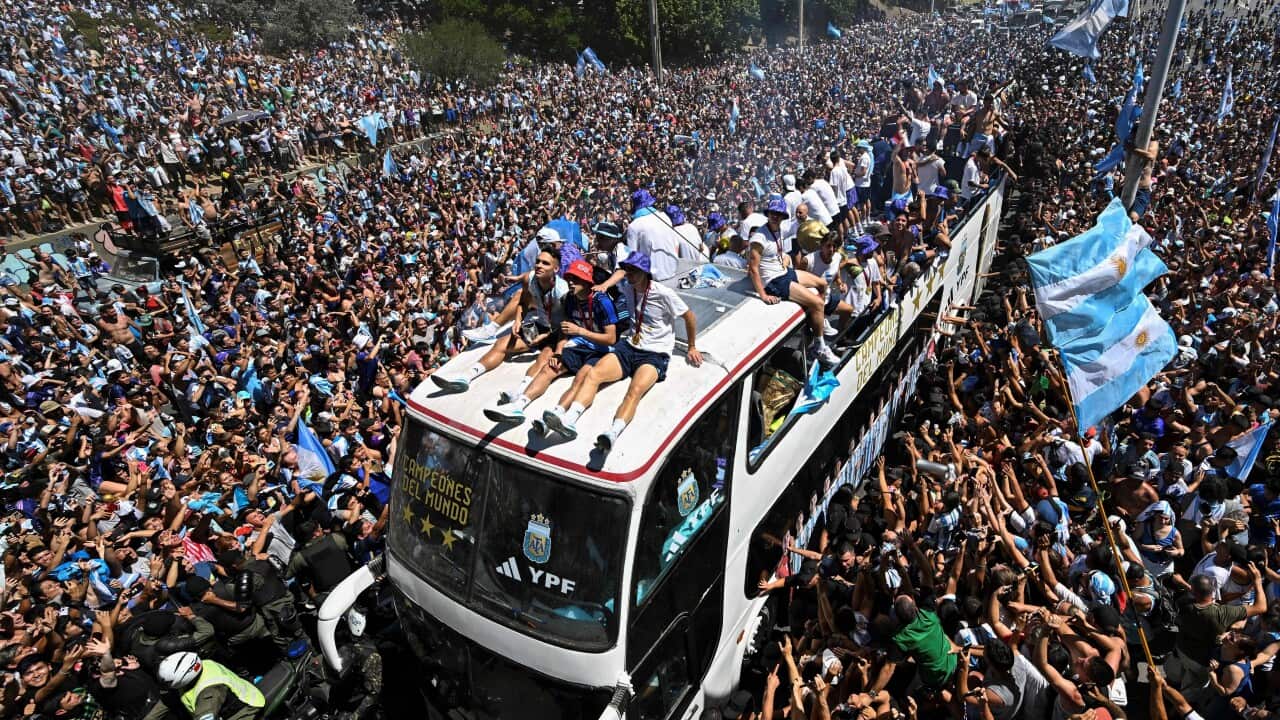Fans of Argentina cheer as the team parades on board a bus after winning the Qatar 2022 World Cup tournament in Buenos Aires, Argentina