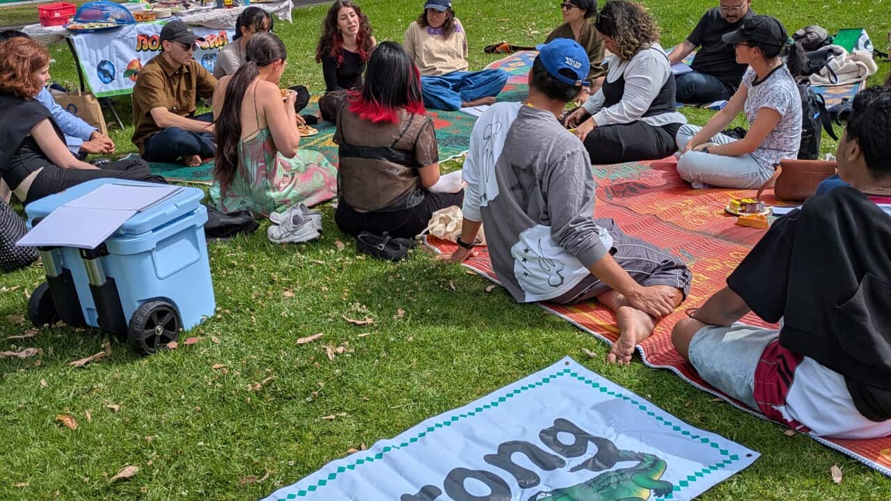 Participants of the 'Barang-Bareng' event sit on mats at Carlton Gardens, sharing stories about their identity through meaningful objects from Indonesia. Credit_ SBS Indonesian_Anne Parisianne.jpg