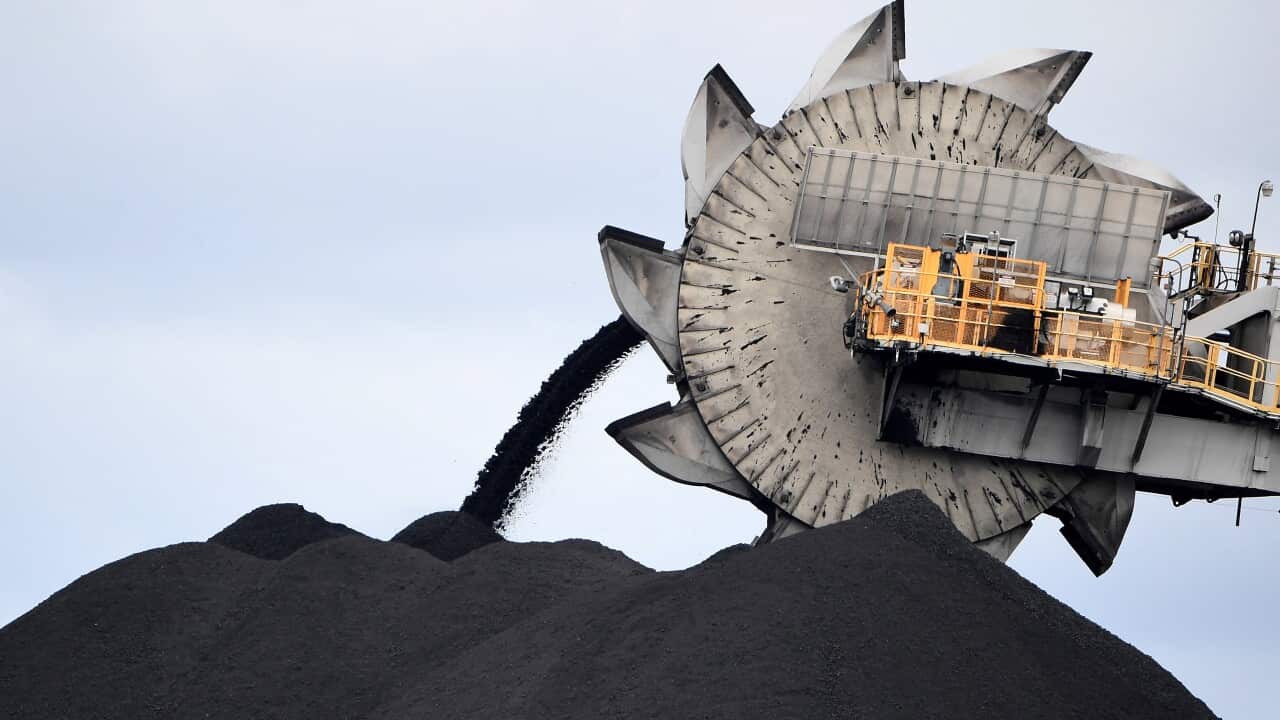 A large bucket-wheel dumping soil and sand removed from a coal mine.