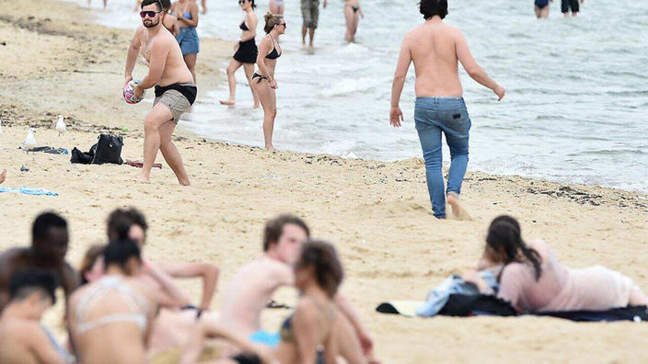 Beachgoers are seen at St. Kilda beach in Melbourne in Melbourne, Tuesday, Dec. 13, 2016. A blast of summer heat has hit Sydney, Canberra, Melbourne and Adelaide with temperatures soaring past 30C. (AAP Image/Julian Smith) NO ARCHIVING