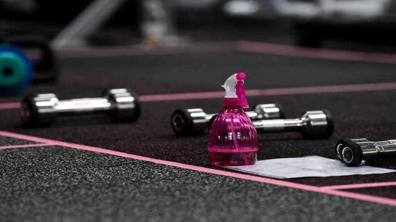 Disinfectant spray is placed around the gym for members to wipe down equipment at a gym in Sydney.