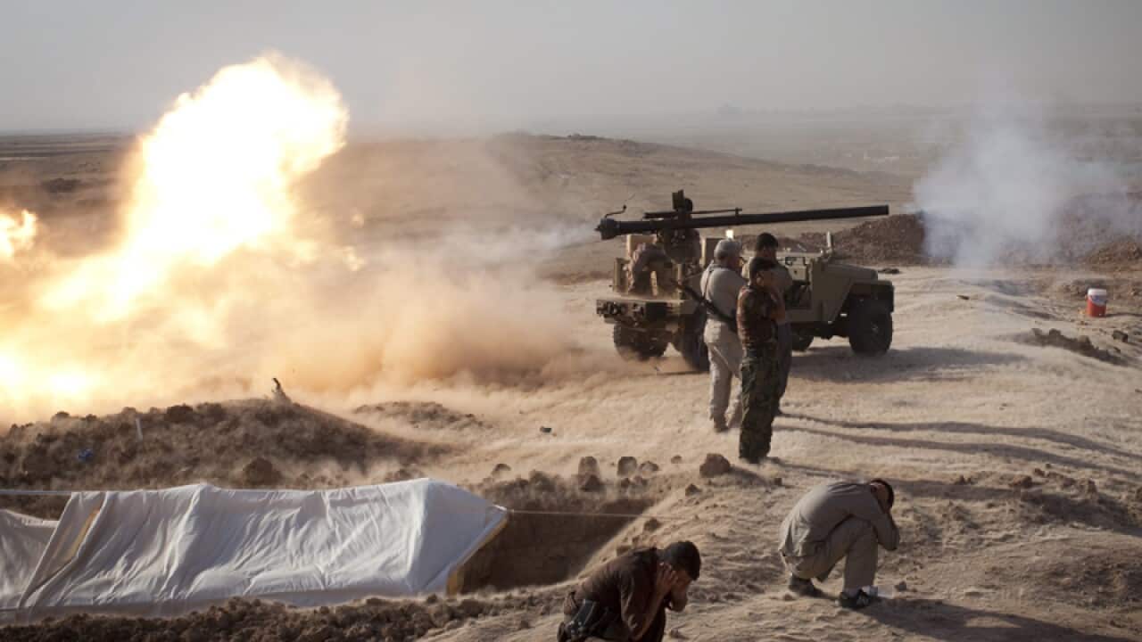 Peshmerga fighters fire a cannon towards Islamic State positions.