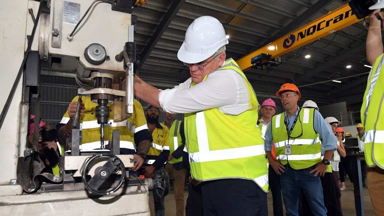 Prime Minister Scott Morrison drills a hole at Norship shipyard engineering facility on Day 18 of the 2022 federal election campaign, in Cairns, in the seat of Leichhardt. Thursday, April 28, 2022. (AAP Image/Mick Tsikas) NO ARCHIVING