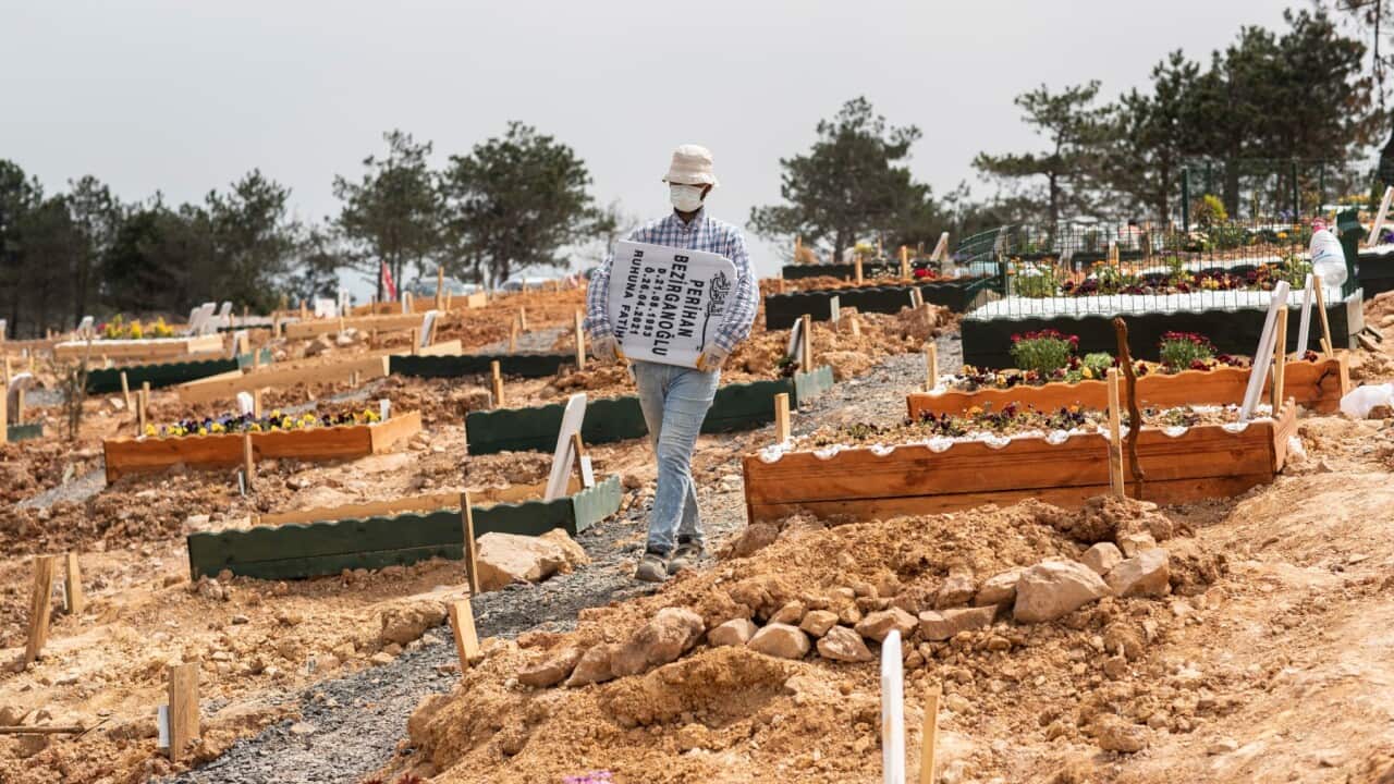 A worker carries a grave stone for newly dead person at Yukari Baklaci Cemetery in Istanbul, Turkey, 28 April 2021. Turkish President Recep Tayyip Erdogan announced a total lockdown between 30 April to 17 May due to increased Covid-19 cases.