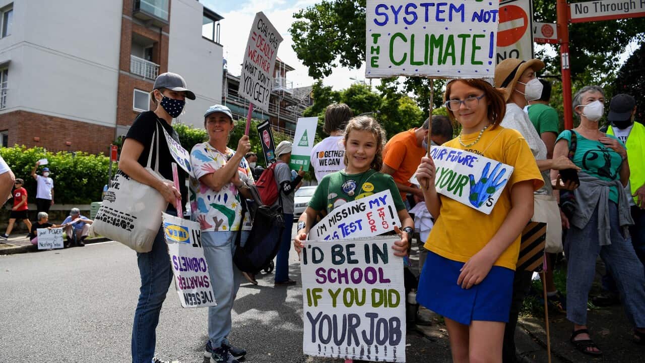 Protesters hold placards during a Climate School Strike protest at Kirribilli House in Sydney, Friday, March 25, 2022.