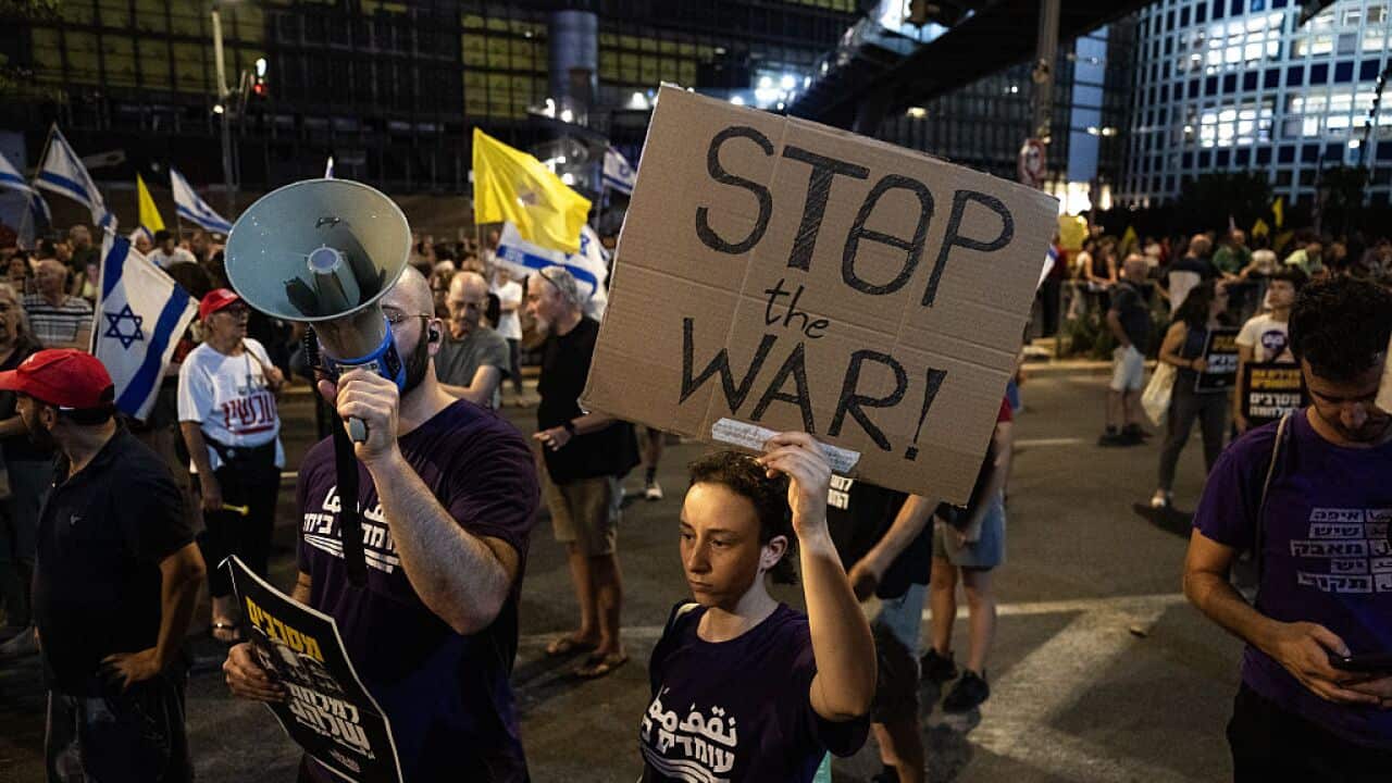 A group of Israeli demonstrators, carrying photos of captives and anti-government banners