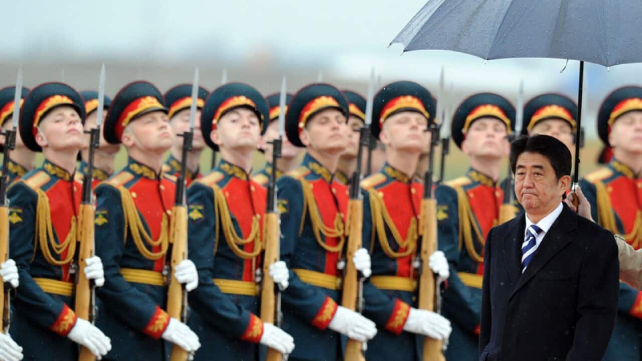 Japanese Prime Minister Shinzo Abe (R) reviews Russian troops as he arrives at Moscow airport. (AFP)