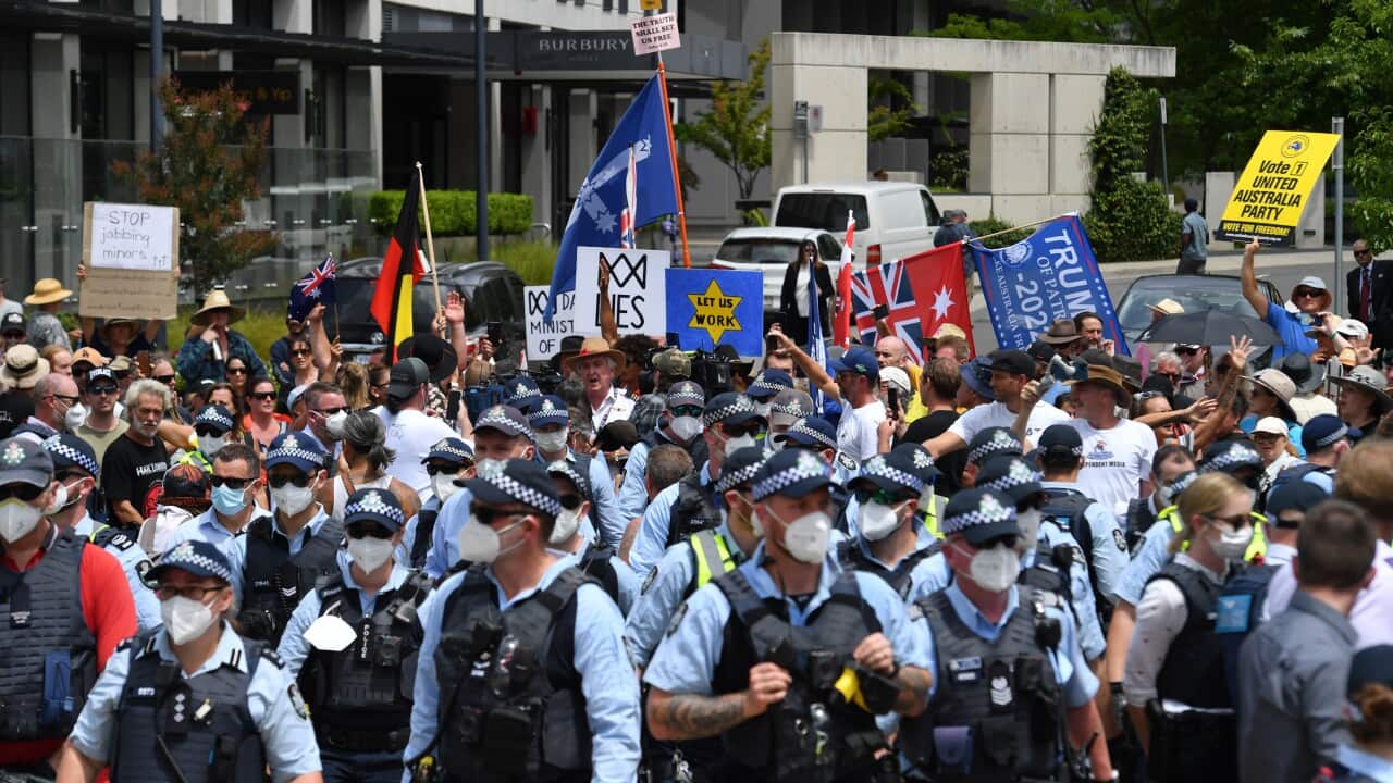 Protesters and police are seen during an anti-vaccination rally outside the National Press Club where Prime Minister Scott Morrison spoke in Canberra.