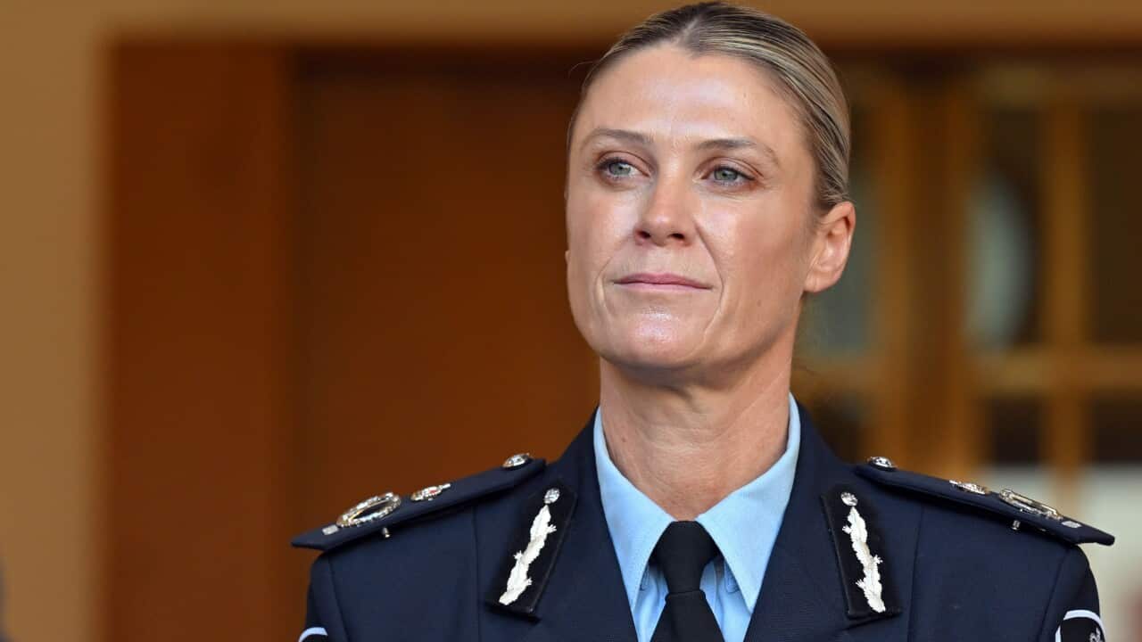 A woman with blonde hair wearing a blue police uniform.
