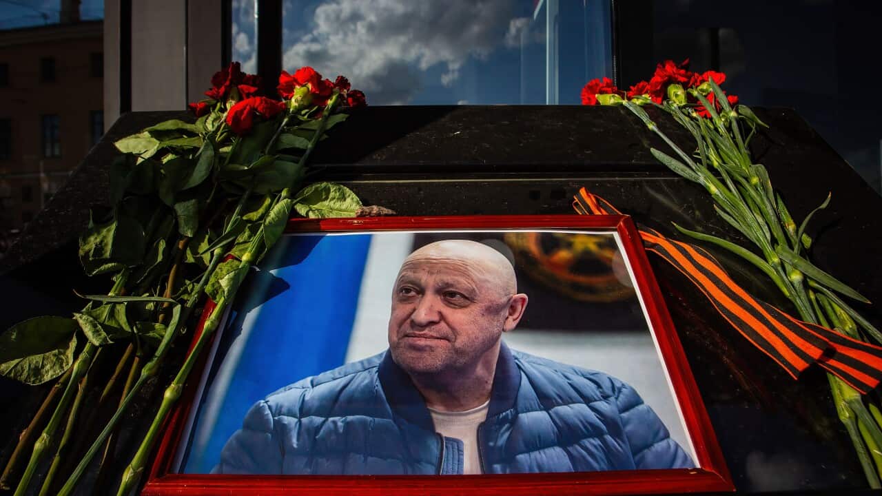 Flowers are laid by a portrait of a man.