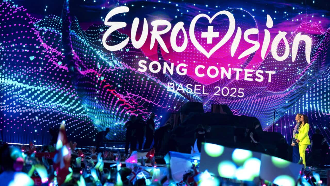 A crowd looking at a stage displaying a screen that says: Eurovision Song Contest Basel 2025