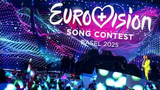 A crowd looking at a stage displaying a screen that says: Eurovision Song Contest Basel 2025