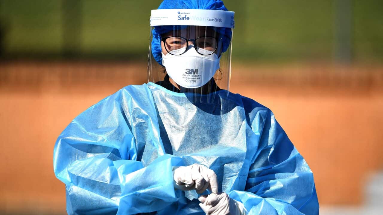 A health worker takes a swab sample at a Covid-19 coronavirus drive through testing site in the Smithfield suburb of Sydney on August 12, 2021. (Photo by Saeed KHAN / AFP) (Photo by SAEED KHAN/AFP via Getty Images)