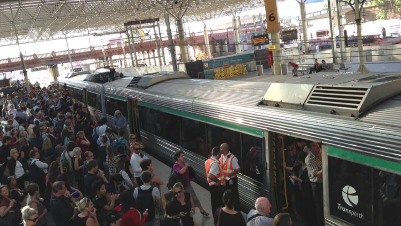 Passengers attempt to board a train at Perth's main train station