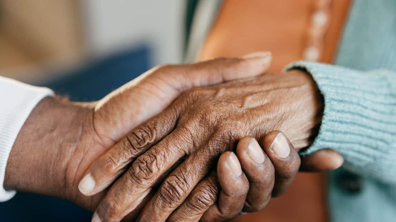 Young woman holding elderly hands