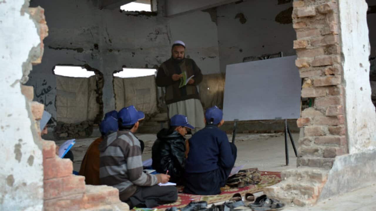 Student studying at a damaged school in Bara Pakistan.