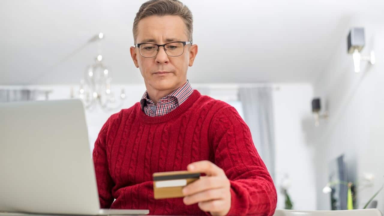 Mature man using credit card