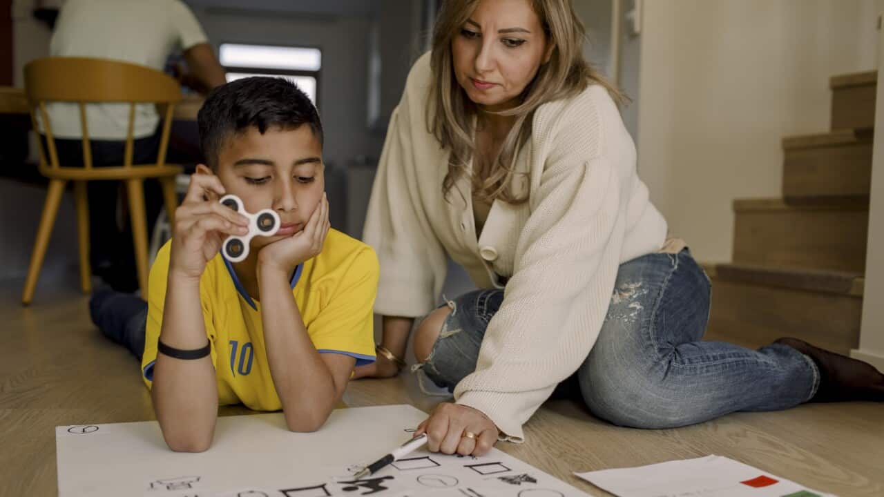 Mother teaching son while sitting at home