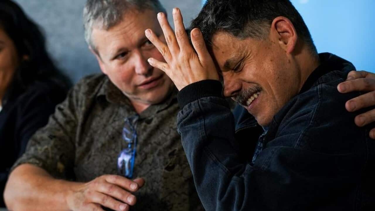 Mark and Adam James comfort each other.