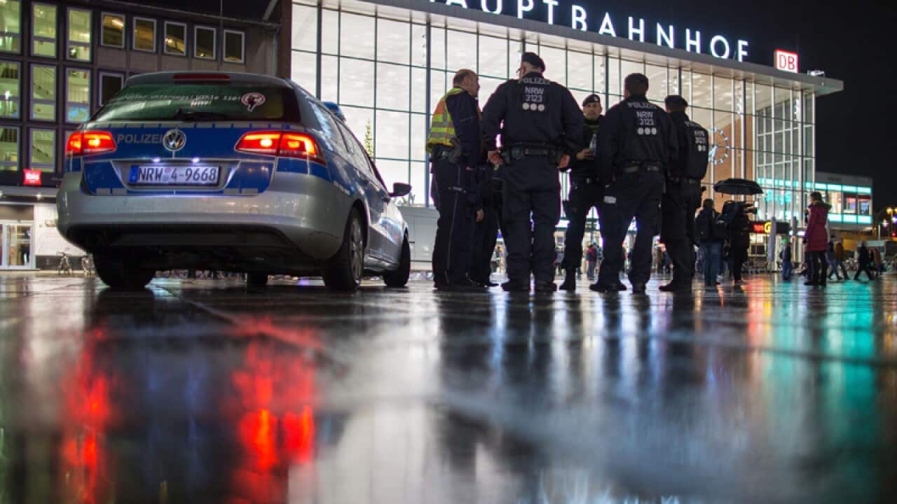 Police officers stand outside the main station in Cologne, Germany