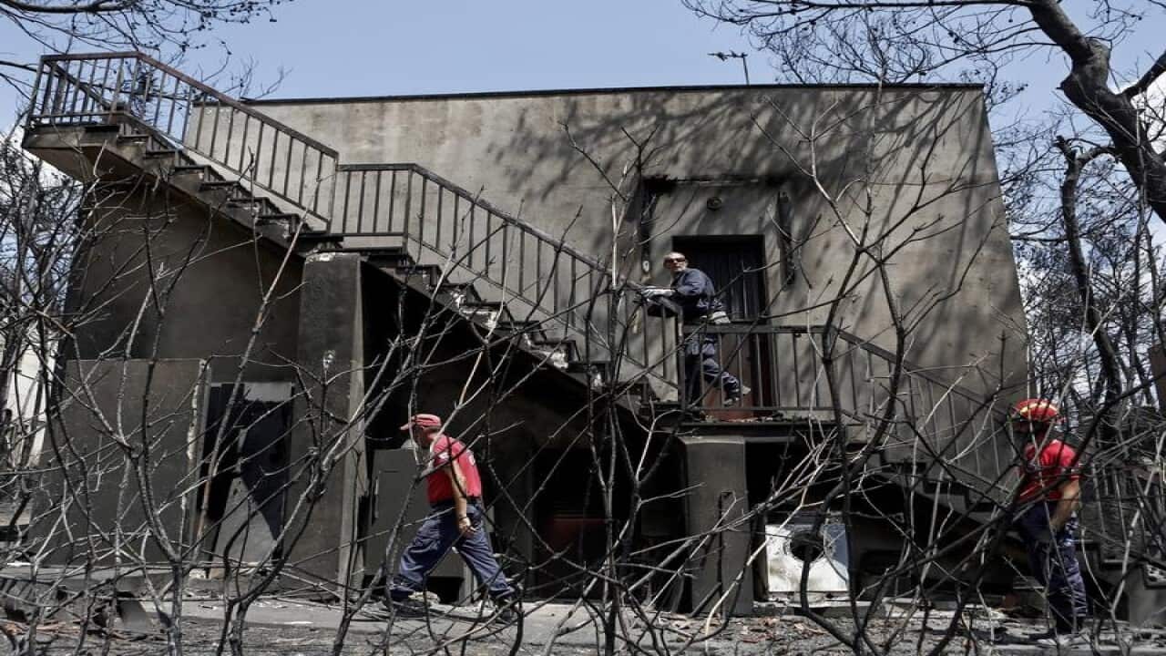 Members of a rescue team search for missing people in a burnt house