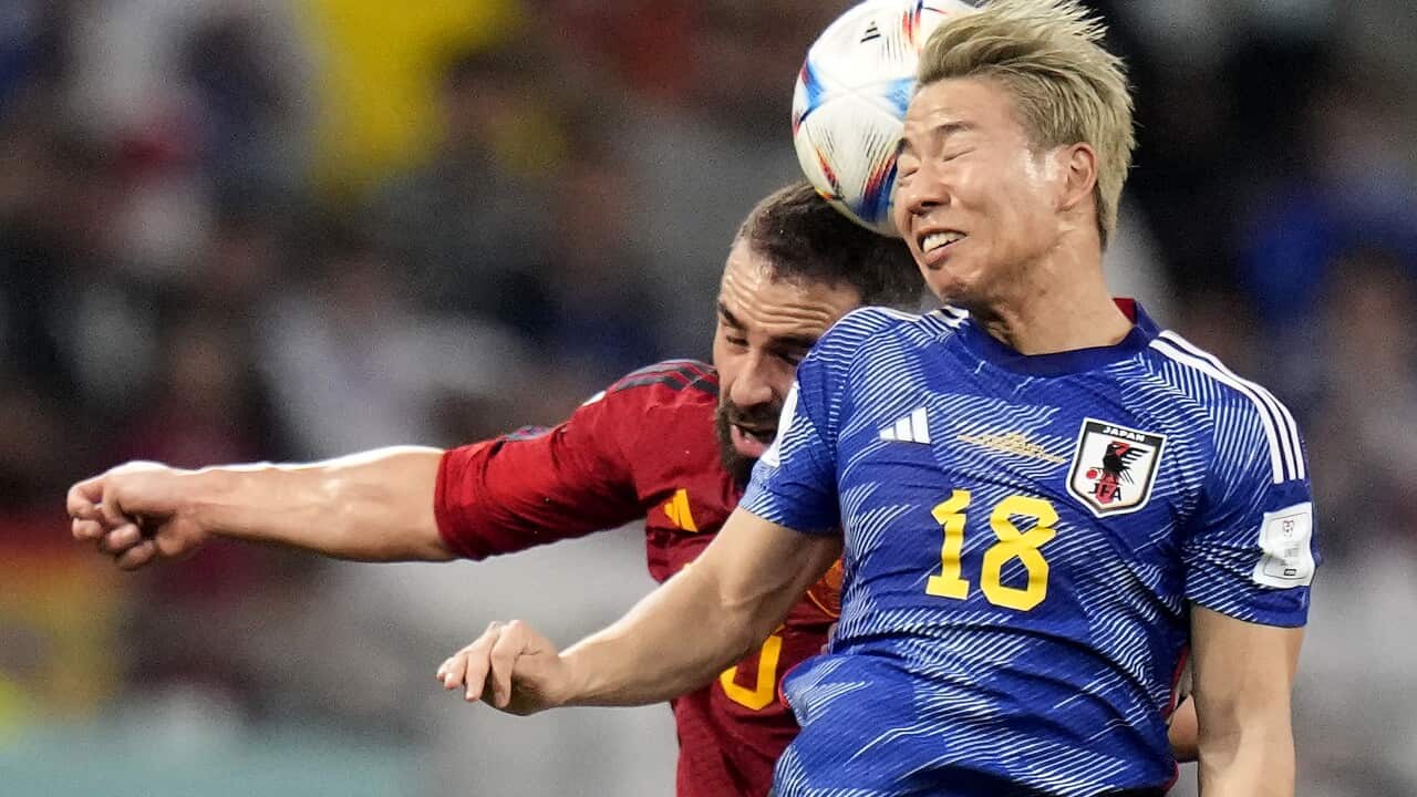 Japan's Takuma Asano knocks the ball with his head and Spain's Dani Carvajal is behind him during play
