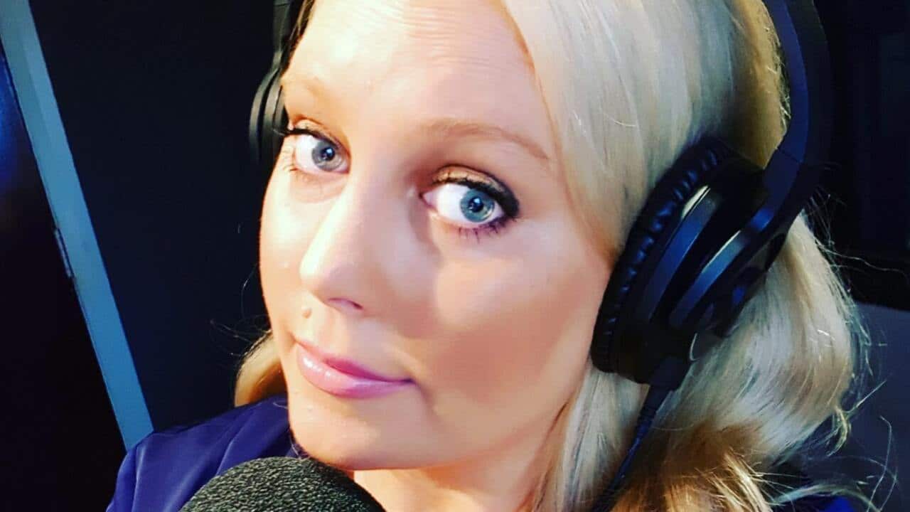 A selfie of Mel Greig holding a mic, working as a radio DJ.