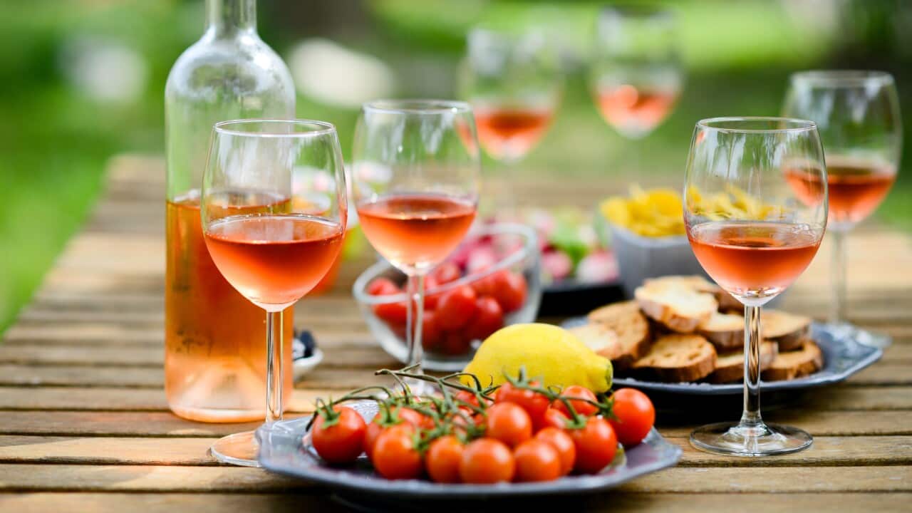 Holiday summer brunch party table outdoor in house backyard with appetizer, glass of rose wine, fresh drink and organic vegetables.