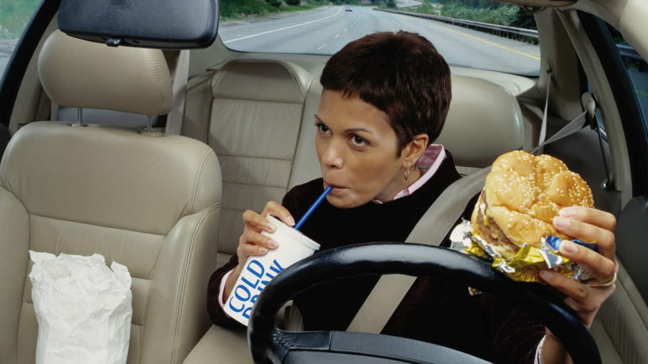 Woman Eating Fast Food While Driving