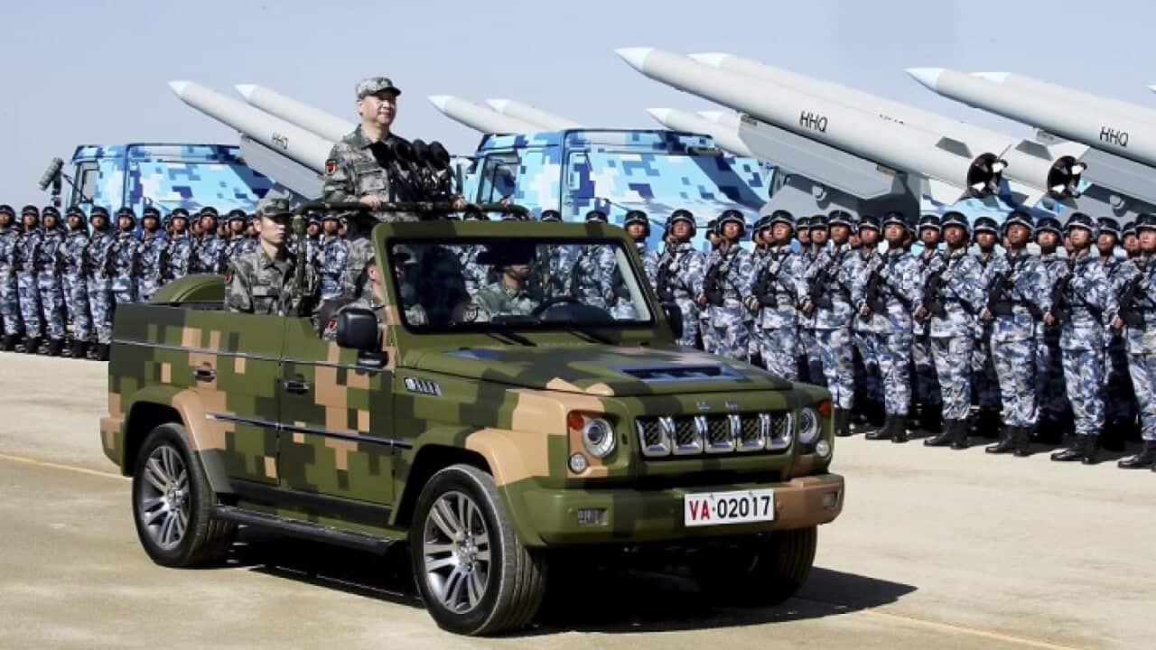 Chinese President Xi Jinping stands on a military jeep as he inspects troops of the People's Liberation Army during a military parade at the weekend.