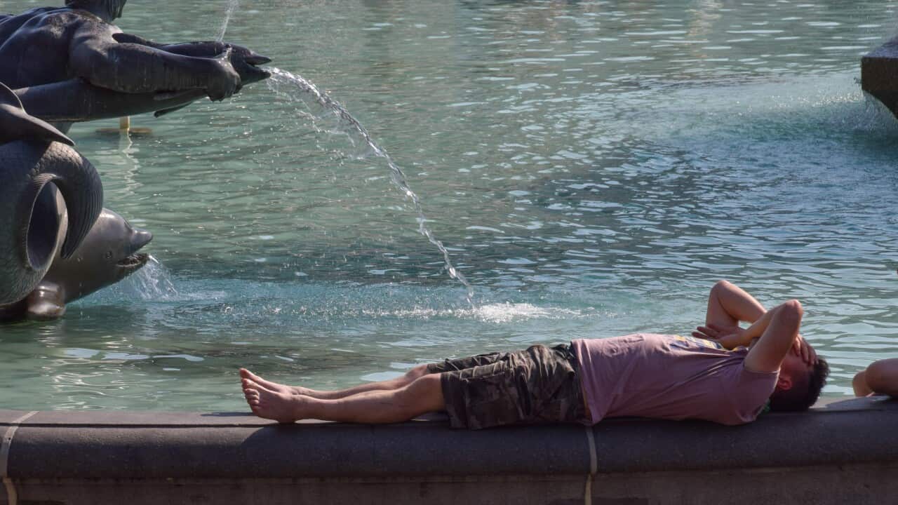 A man lays down next to the fountain at Trafalgar Square as the UK records its highest ever temperatures. The Met Office has issued its first-ever red warning over extreme heat in the UK. (Photo by Vuk Valcic / SOPA Images/Sipa USA)