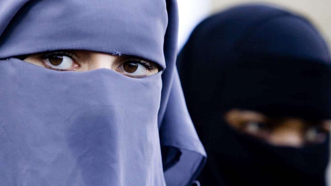 Woman are seen wearing a niqab outside the Dutch parliament