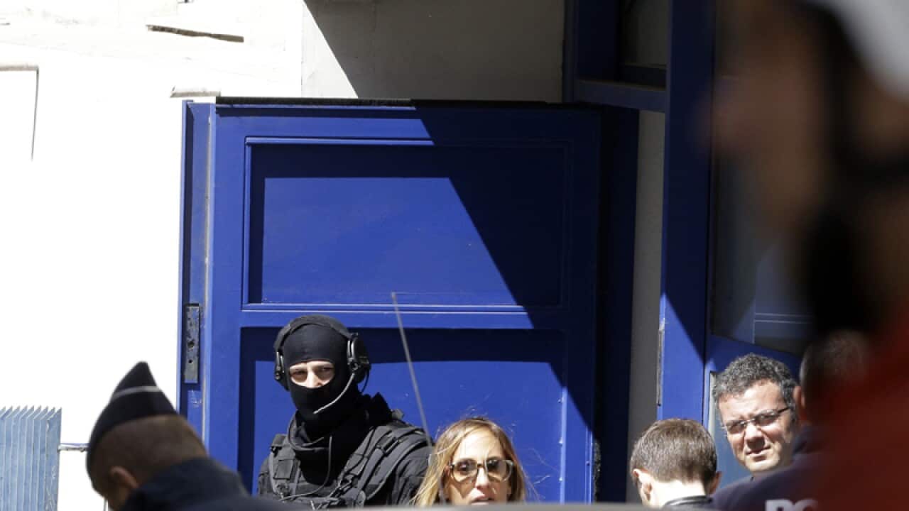Police officers outside a building during a raid in Marseille