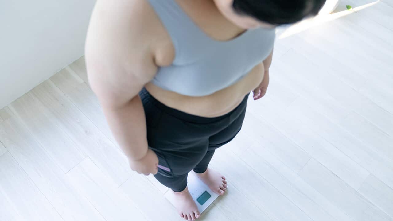 woman standing on weight scale