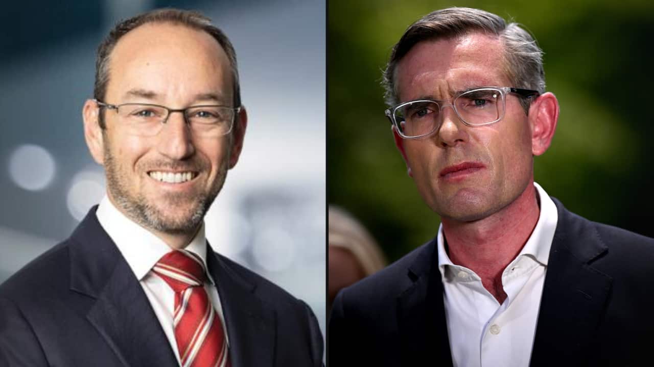 A composite image of two white men wearing navy suits and glasses. One is smiling, hwile the other looks concerned