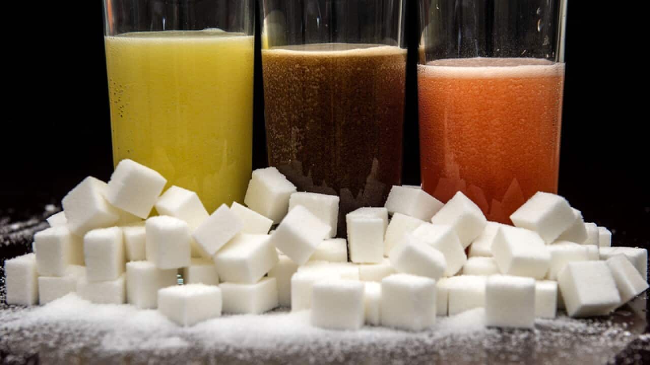 Carbonated drinks surrounded by sugar cubes.
