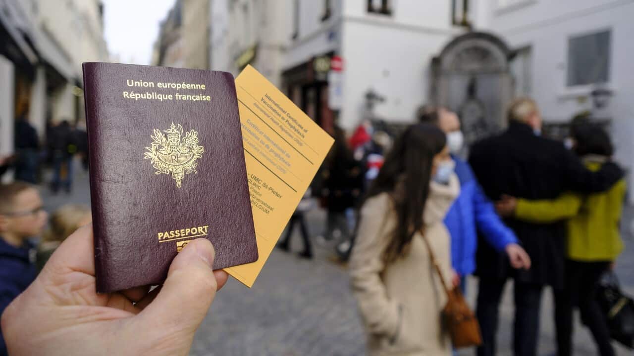 A French passeport and an International Certificate of Vaccination or Prophylaxis are seen in an illstration pictures on February 19, 2021 in Brussels, Belgium. Back is the famous statue of the Manneken-Pis. - Photo by Monasse T/ANDBZ/ABACAPRESS.COM.