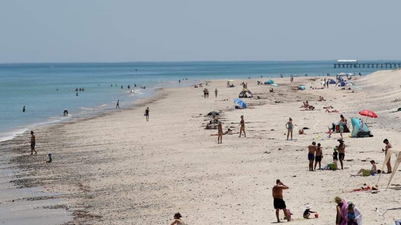 Beach goers cool off at West Beach in Adelaide.
