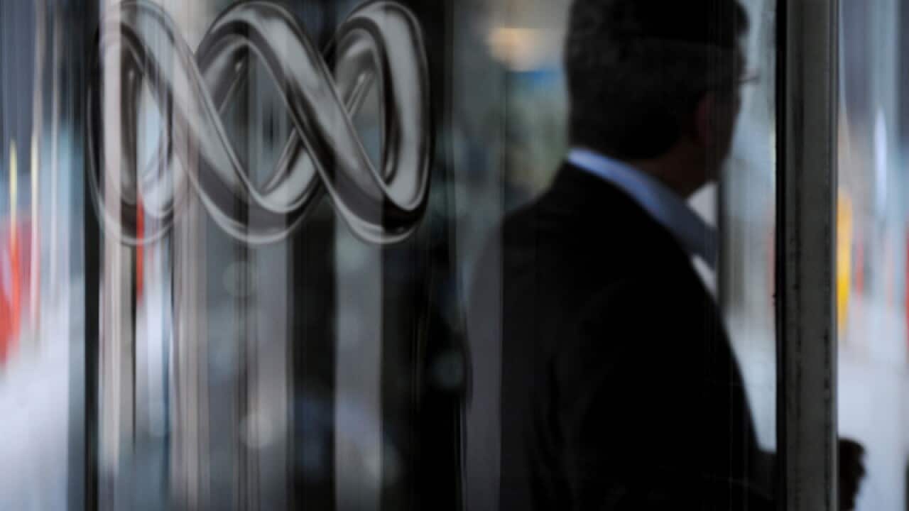 File photo of a man walking past an ABC logo