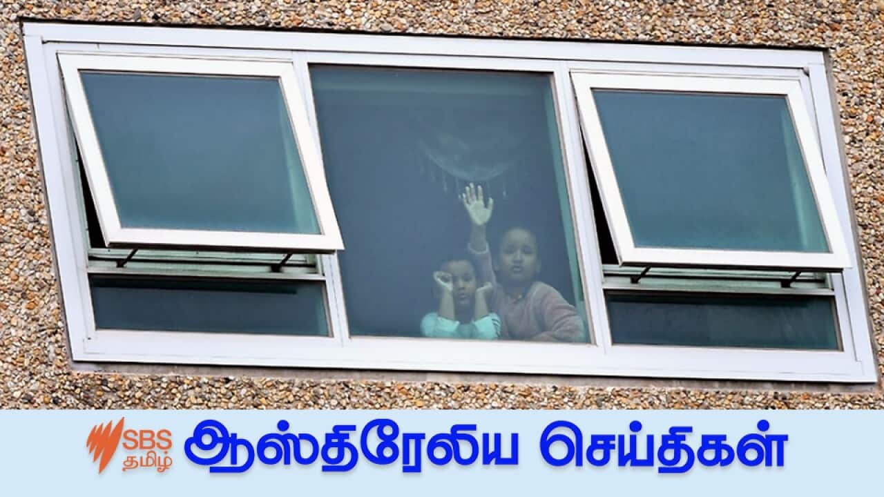 Children from a window inside a unit at the public housing tower along Racecourse Road in Melbourne.