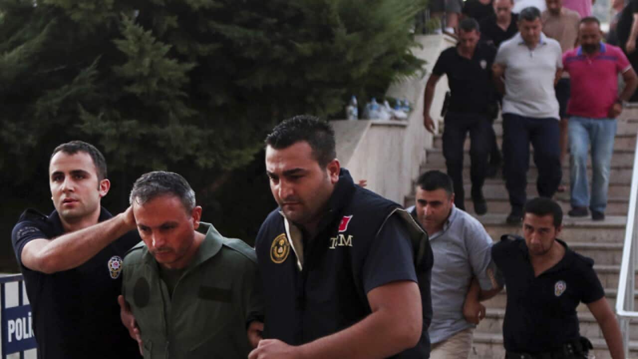 Members of Turkey armed forces are escorted by police