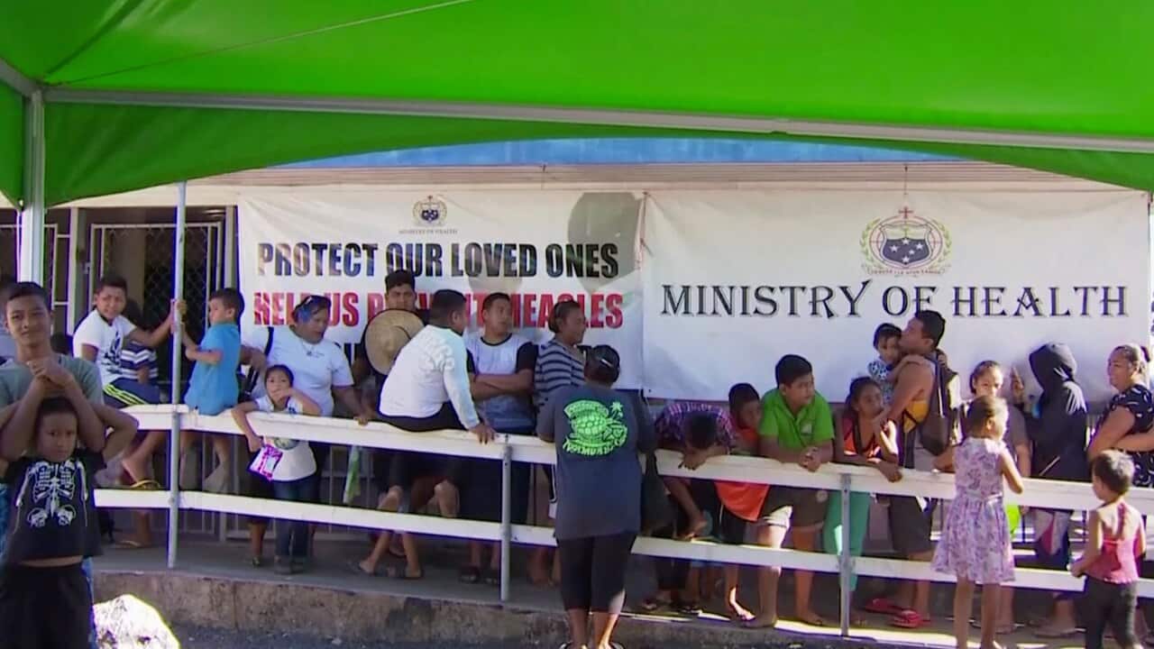 Children with parents wait in line to get vaccinated outside a health clinic in Apia, Samoa.