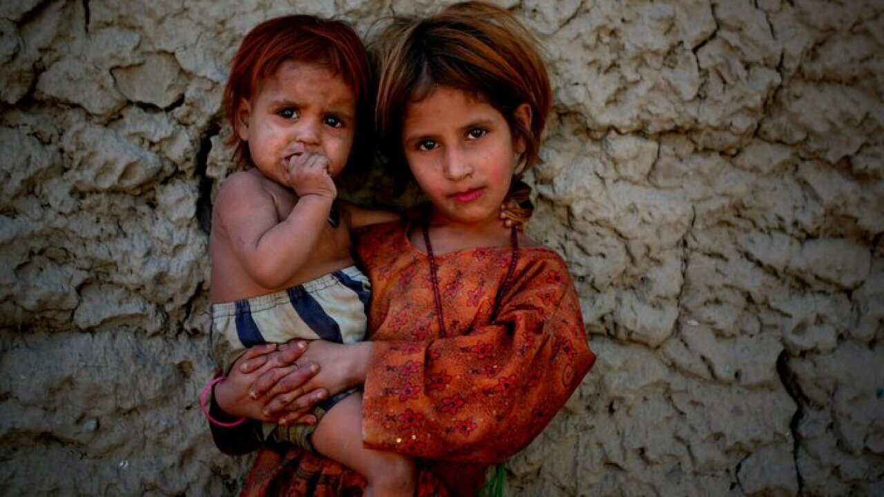 Zubaida, an Afghan girl holds her younger sister as she poses for a photograph in Jalalabad, Nangarhar province, east of Kabul, Afghanistan.