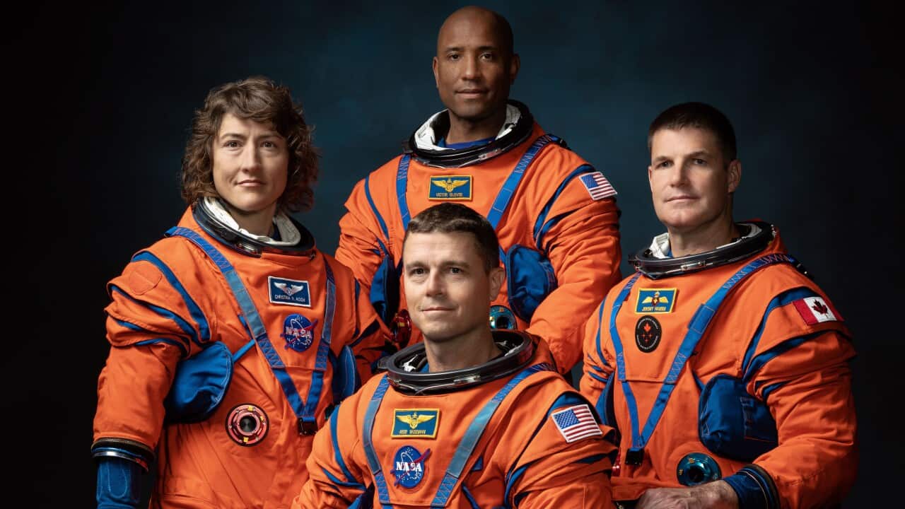 Four astronauts dressed in orange space suits - the crew of NASA's Artemis II mission featuring the first woman and black astronaut to head to the moon.