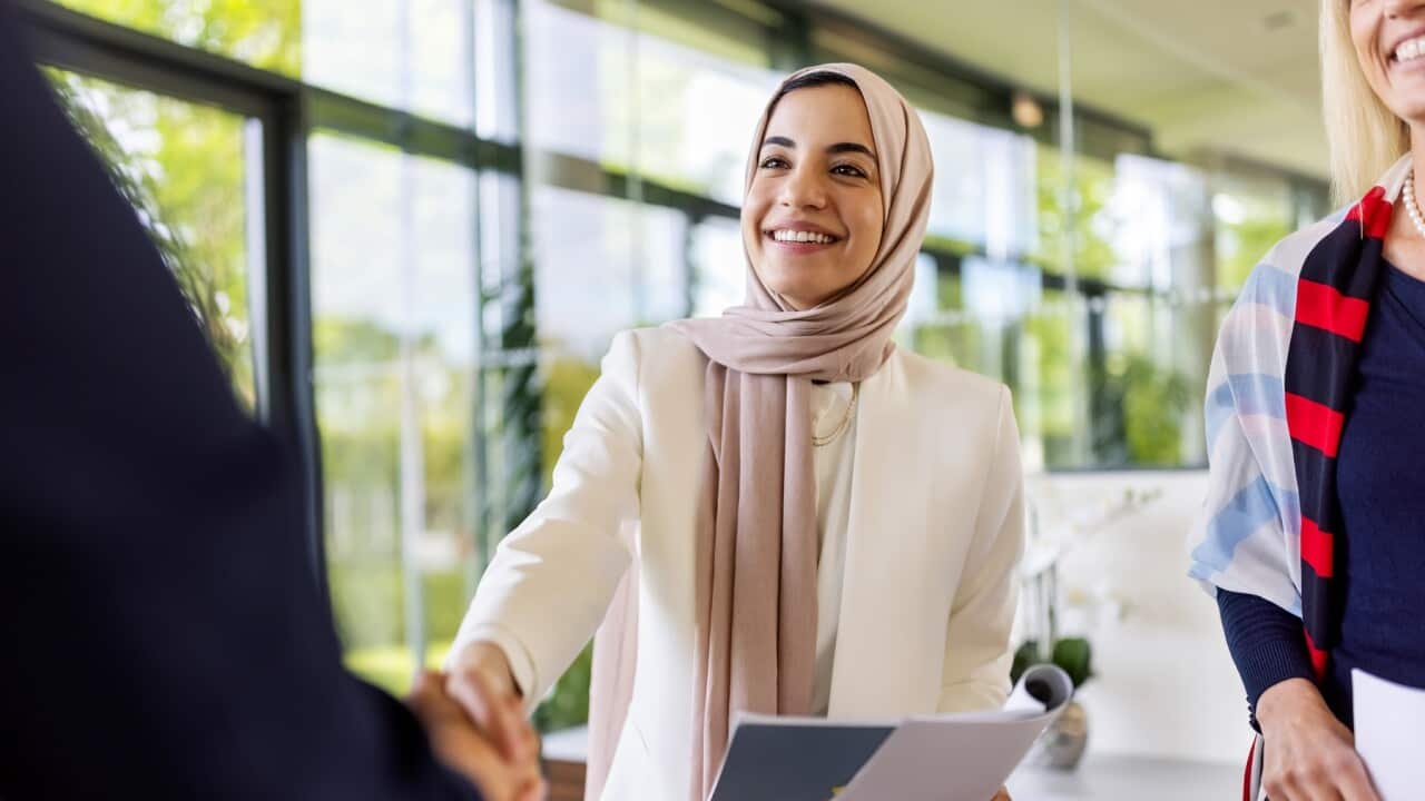 Muslim businesswomen sealing a deal with a handshake