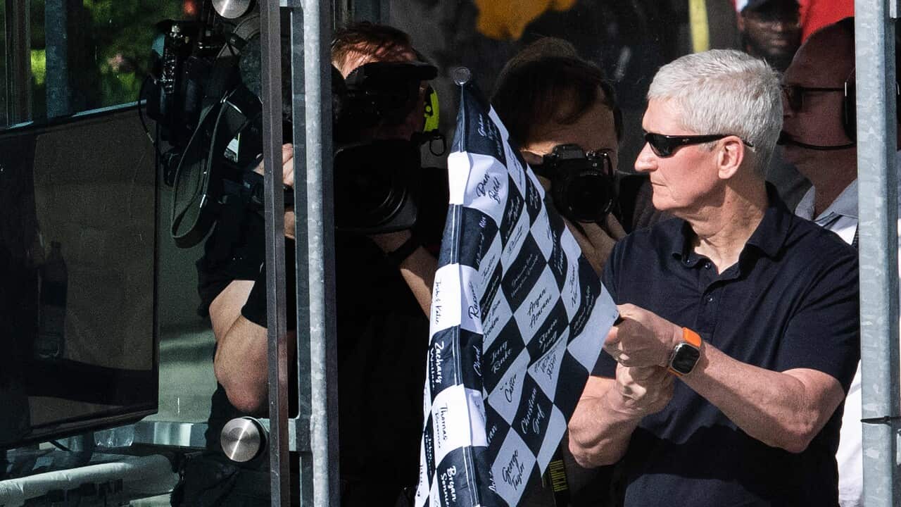Tim Cook holds a chequered flag